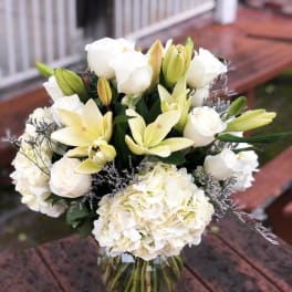 White roses and lilies arranged in a glass vase