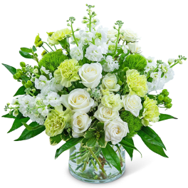 White and pale green floral arrangement in a clear glass vase