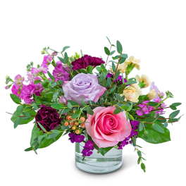 Pink and lavender roses in a clear glass vase
