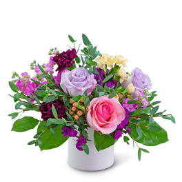 Pink and lavender roses in a white vase with purple and cream flowers