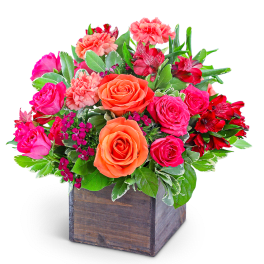 Pink and orange roses with red alstroemeria in a wooden box
