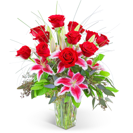 Red roses and pink lilies in a clear glass vase
