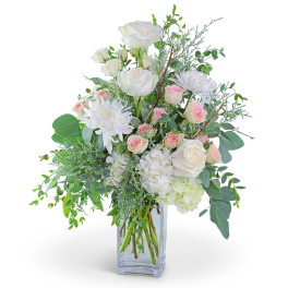 White roses and pink spray roses in a clear glass vase