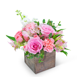 Pink and white floral arrangement in a rustic wooden box