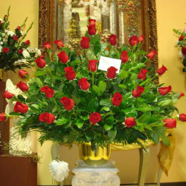 Large arrangement of red roses in a gold vase