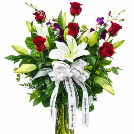 Bouquet of red roses and white lilies with a white anniversary ribbon