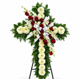 Cross-shaped floral spray with red roses and white chrysanthemums on a stand