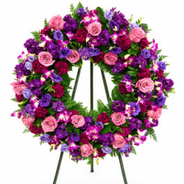 Purple and pink floral wreath on a stand