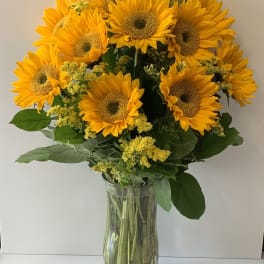 Bouquet of yellow sunflowers in a clear glass vase