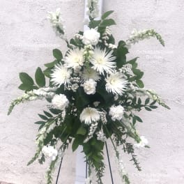 White floral standing spray on a black easel
