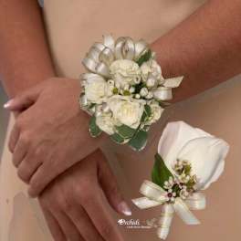 Two white floral wrist corsages worn on arms, each tied with ribbon.