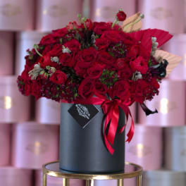 Large red rose bouquet in a black hat box with ribbon