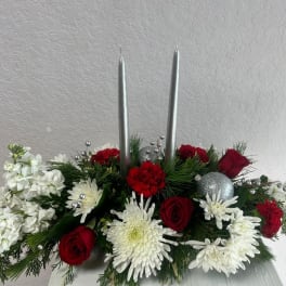 Red and white floral centerpiece with two silver taper candles