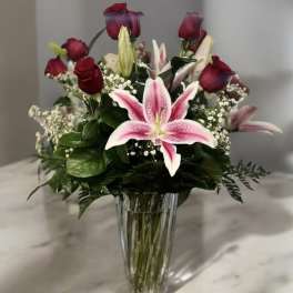 Pink lilies and red roses in a clear glass vase