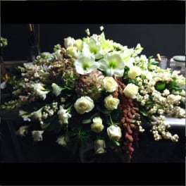 Large white floral arrangement with roses and lilies