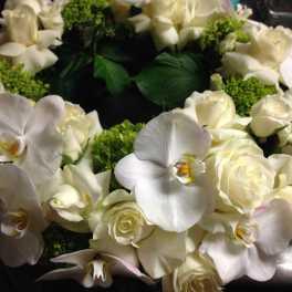 White rose and orchid wreath with green accents