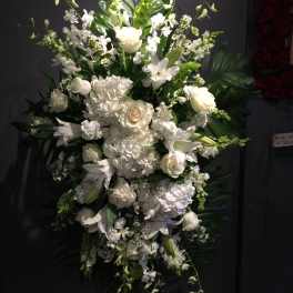 Tall white floral standing spray with roses, lilies, and hydrangeas