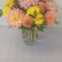 Pink and yellow dahlia bouquet in a clear glass vase