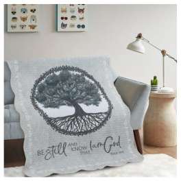 Tree-themed quilt draped over a sofa in a living room