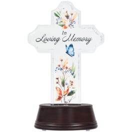Cross-shaped memorial plaque with floral accents on a dark base