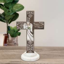 Decorative memorial cross on a white base with an angel and flowers