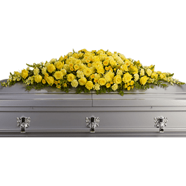 Yellow rose casket spray on a silver casket