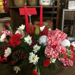 Red and white floral arrangement with candles and a patterned ribbon