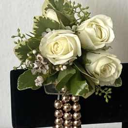White rose bouquet with green foliage and a beaded handle