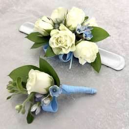 White rose corsage and boutonniere with blue ribbon accents