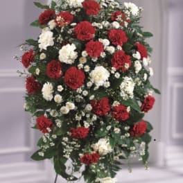 Standing floral spray with red and white carnations on a tripod easel