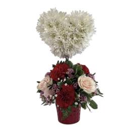Heart-shaped white chrysanthemum topper above a red and blush rose arrangement in a vase