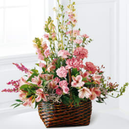 Pink mixed flower arrangement in a woven basket