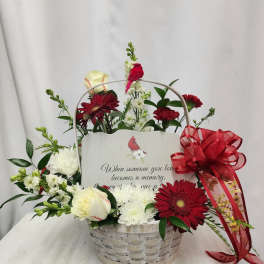 Basket arrangement with red and white flowers and a memorial card