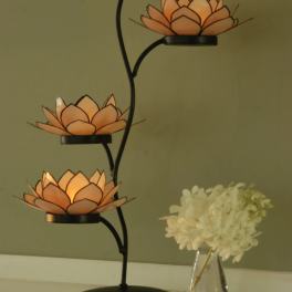 Three orange lotus-shaped candle holders on a black metal stand
