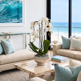 White orchid arrangement in a metallic pot on a coffee table