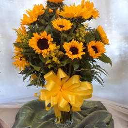 Sunflower arrangement in a glass vase with a yellow bow