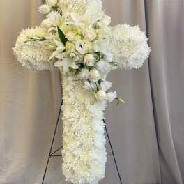 White floral cross arrangement on a stand