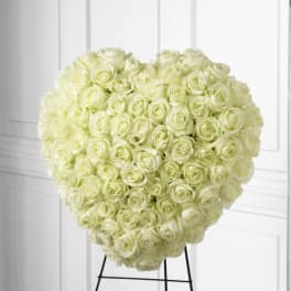 Heart-shaped arrangement of white roses on a stand