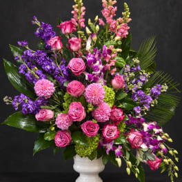 Pink and purple mixed flower arrangement in a white vase