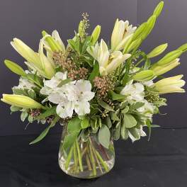 White lilies and alstroemeria in a clear glass vase