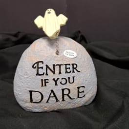 Ghost figurine on a painted stone with "Enter if you dare" text