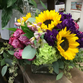 Bouquet with sunflowers, pink roses, purple blooms, and green hydrangea