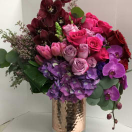 Bouquet of pink, purple, and burgundy flowers in a glass vase