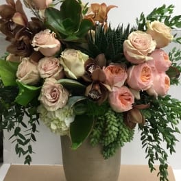 Bouquet of blush roses and orchids in a tall vase