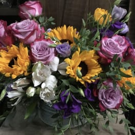 Bouquet of pink roses, sunflowers, and white flowers in a vase