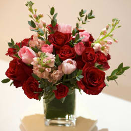 Red and pink roses arranged in a clear glass vase