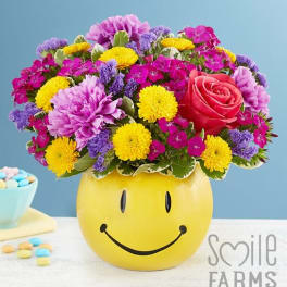 Colorful mixed bouquet in a yellow smiley-face vase