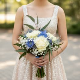 Woman holding a bouquet of white roses and blue flowers