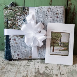 Wrapped gift with a white ribbon and a greeting card beside it