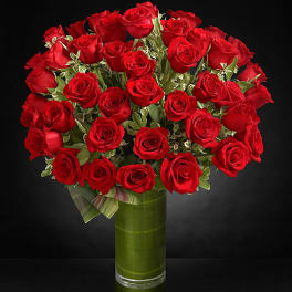 Bouquet of red roses in a tall glass vase